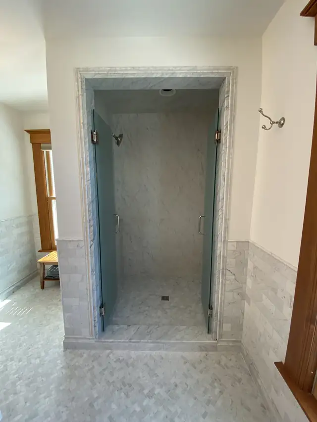 Walk-in shower bathroom remodel near Ames, Iowa with frameless glass doors, white marble tile and mosaic floor